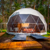 Geodesic dome structure with outdoor furniture in a forest setting