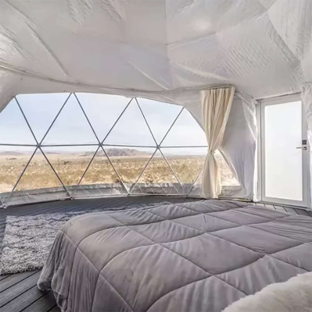 Bedroom inside a geodesic dome with a view of the landscape