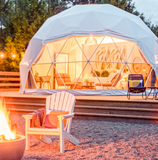 Geodesic dome with interior lighting, outdoor seating area, and fire pit.