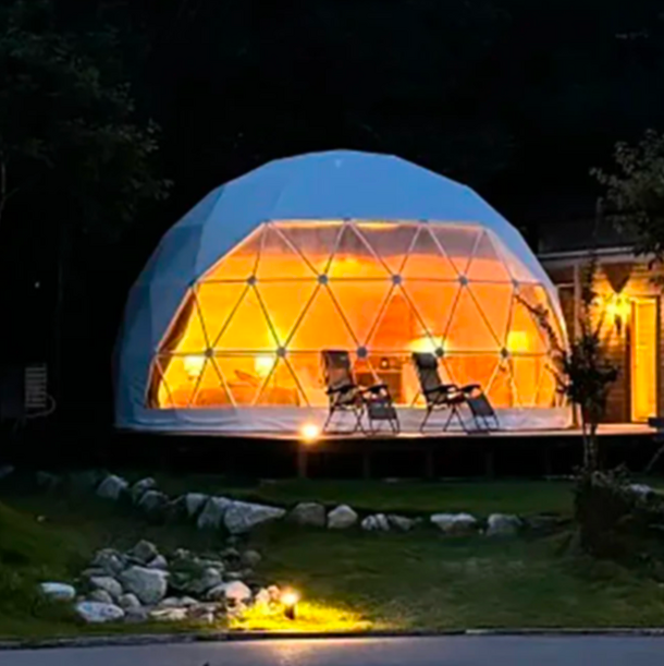 Geodesic dome tent with interior lighting in a garden setting